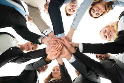 Confident Business Team Stacking Hands While Standing In Huddle